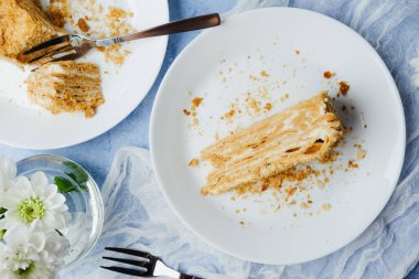 Napolyon millefeuille pastası. Beyaz tabaklarda krema katmanları olan tatlı.