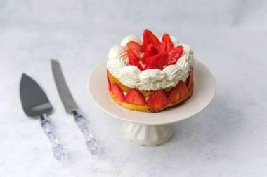 Kutlama masası ya da tatlı yemek promosyonu için beyaz tabak üzerine çilekli pasta.