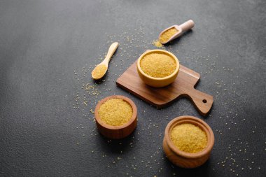 Kaşık ve arka planda çatlamış buğday lapası taneleri olan bir sürü kase. Sağlıklı Çiğ Tahıl Taneleri.