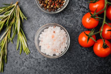 Koyu arkaplanda kiraz domatesli, biberiyeli pembe himalaya tuzu.