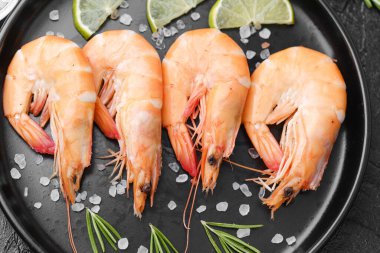 Biberiye, tuz ve zeytin ile servis edilen karides gurme aperatifler veya restoran menüsü konsepti için siyah tabakta