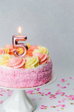 Beşinci yaş günümü kutlamak için renkli kremalarla süslenmiş enfes pembe bir pasta..