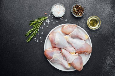 Tavuk budu çiğ, baharatlı ve otlu beyaz tabakta.