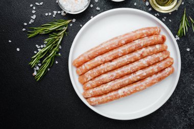 Beyaz tabakta taze domuz sosisi ve baharat.