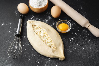 Çiğ khachapuri ile kaplanmış yüzey, yumurta ve fırın için merdane.