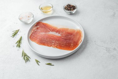 Biberiye ve tuzlu beyaz tabakta jambon dilimleri.