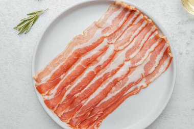 Pişmemiş pastırma şeritleri beyaz tabakta biberiye ve baharatla.