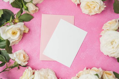 Pembe arka planda beyaz güller çerçeveli boş beyaz kart