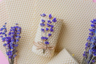 Balmumu mumlar ve pembe arka planda lavanta demetleri