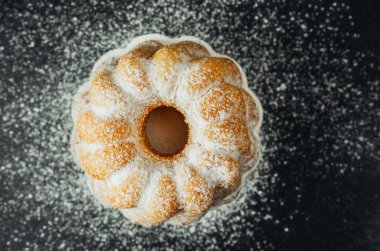 Siyah arkaplanda pudra şekerli kek 