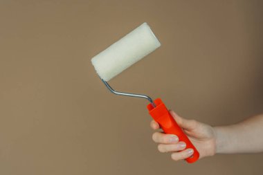 El ele tutuşan kırmızı paten fırçası kahverengi üzerine izole edilmiş boya ve vites konsepti