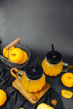 Cam kavanozlarda pipetli sarı balkabağı içecekleri karanfil ve yıldız anasonlu mini balkabakları.