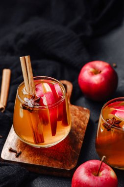 Tarçın çubuklu baharatlı elma şarabı ve gözlüklü yıldız anasonu. Tahtada servis edilmiş..