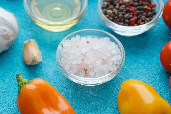 Mavi arka planda siyah biber, tuz, domates ve biber yakın çekim