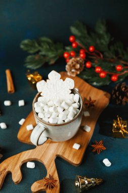 Şekerlemeler ve kar taneli kurabiyelerle dolu sıcak bir fincan.