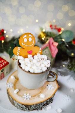 Zencefilli kurabiye sıcak çikolata bardağında oturur. Kış süslemeleriyle çevrili şekerlemelerle..