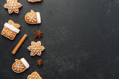 Bayram zencefilli kurabiyeleri kar tanesi eldiven hediye kutusu tarçın çubuk yıldız anason koyu yüzeye yayılmış.