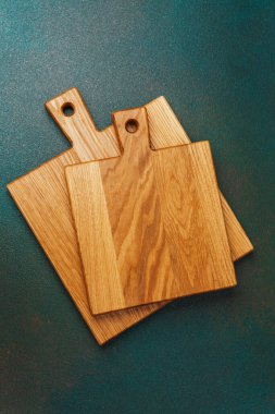 İki tahta kesme tahtası yeşil arka planda sergileniyor..