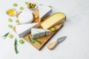 Peynir tabağı, çeşitli peynirler, zeytinler ve taze üzümler..