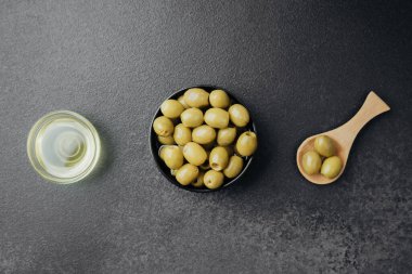Koyu arkaplanda yeşil zeytin ve zeytin yağı