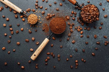Ground Coffee ve gri arka planda kepçeli fasulyeler.