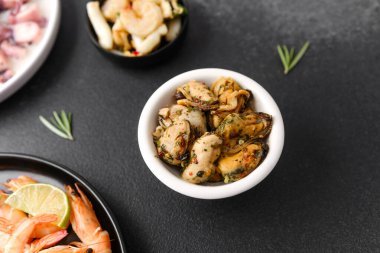 Deniz ürünleri menüsü ya da sağlıklı yaşam tarzı konsepti için otlu beyaz kasede midyeler.