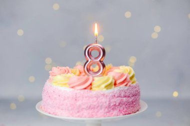Sekizinci yaş günü kutlamasını simgeleyen bir pasta ve bir mum..