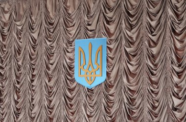 Ukrayna ulusal amblemi resmi bir ortamda savurgan örtülü bir zemin üzerinde sergilendi.