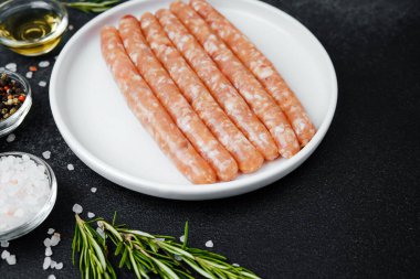 Beyaz tabakta taze domuz sosisi ve baharat.