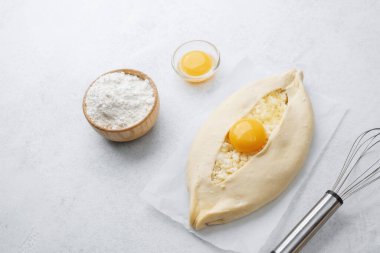 Yumurta sarısı ve beyaz arka planda çırpılmamış khachapuri.