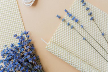 Balmumu mumu ve bal peteği yapraklı lavanta ve bej arkaplan.