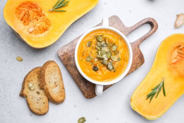 Kabak tohumlu kabak çorbası ve tahtanın üzerinde ekmek.