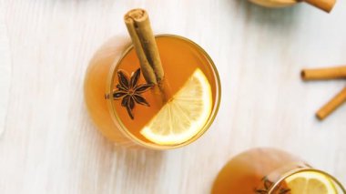 Limon dilimli sıcak baharatlı içecek, tarçın çubuğu ve berrak bardakta yıldız anason.