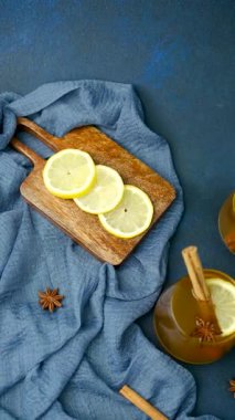 Limon dilimli sıcak içecek, tarçın çubukları ve mavi kumaşta yıldız anason..