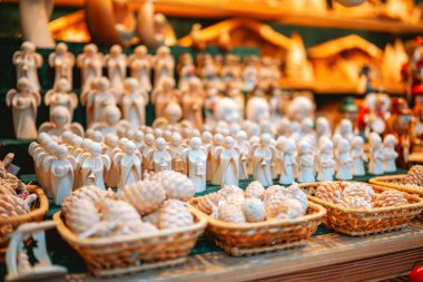 Küçük tahta melekler sıra sıra dizilmiş şenlikli dekorasyonlar ve dokuma sepetlerde çam kozalakları sergiliyorlar..