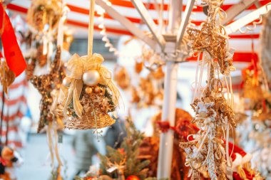 Altın Noel süsleri açık hava dekorlarıyla market tezgahında asılı duruyor.