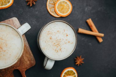 Tarçınlı, baharatlı, kurutulmuş portakal dilimli ve tarçınlı iki bardak ılık krema..