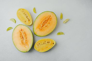 Kavun ve sarı kavun dilimleri hafif bir yüzey üzerinde kireç kamaları