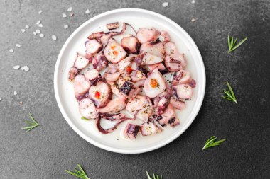 Sağlıklı deniz ürünleri veya fitness diyeti konsepti için biberiye ve tuz ile marine edilmiş beyaz ahtapot tabağı.