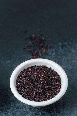 Siyah pirinç beyaz kasede koyu arka planda gevşek taneli