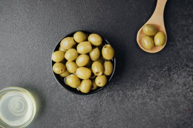 Koyu arkaplanda yeşil zeytin ve zeytin yağı