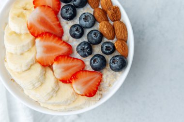 Sağlıklı kahvaltı kasesi ve muzlu yaban mersinli badem sosu.