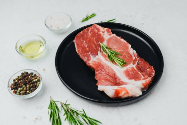 Biberiyeli domuz bifteği, siyah tabakta baharatlı.