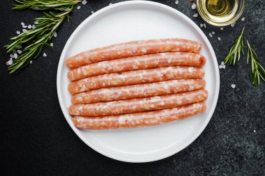 Beyaz tabakta taze domuz sosisi ve baharat.