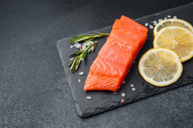 Parlak somon filetosu limon dilimleri ile eşleştirilir ve tahta üzerine otlarla süslenir..