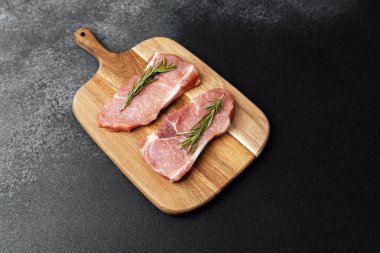 Biberiyeli leziz domuz pirzolası yemek hazırlığı için tahta kesme tahtasına konmuş..