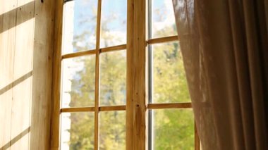 Güneşli bir sonbahar gününde eski ahşap pencerelerden ışık akıyor.