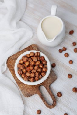 Sağlıklı fındık sütü sürahide fındık kabı tahtanın üzerinde