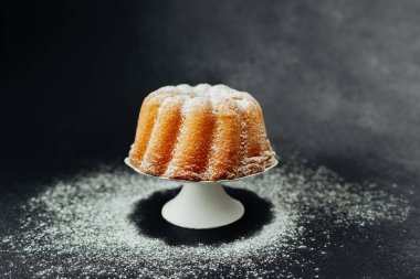 Koyu taşlı, beyaz tezgahta altın demet kek.