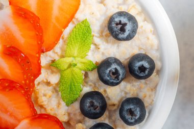 Taze meyve ve nane yapraklı yulaf ezmesi.